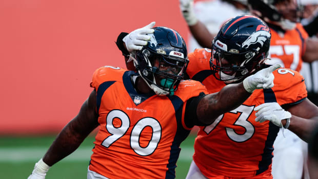 Denver Broncos defensive tackle DeShawn Williams (90) celebrates his sack with defensive end Dre'Mont Jones (93) in the third quarter against the Miami Dolphins at Empower Field at Mile High.